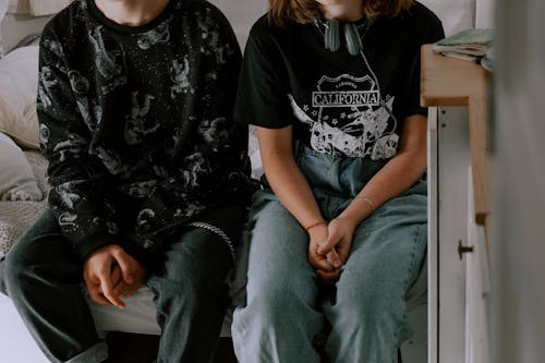 Woman in Black and White Crew Neck T-shirt Sitting Beside Woman in Black and White