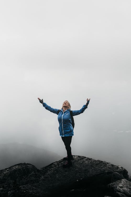Smiling tourist on mountain under foggy sky