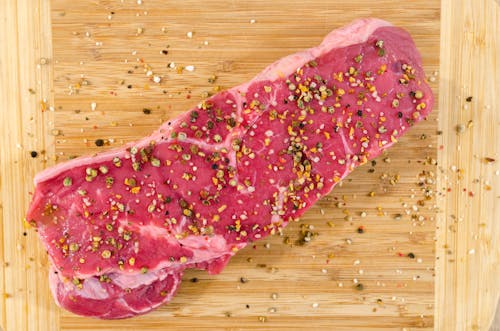 Free Raw Meat on Beige Wooden Surface Stock Photo