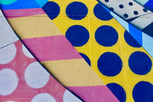 Vibrant geometric wall mural with bold colors and patterns featuring circles and stripes.