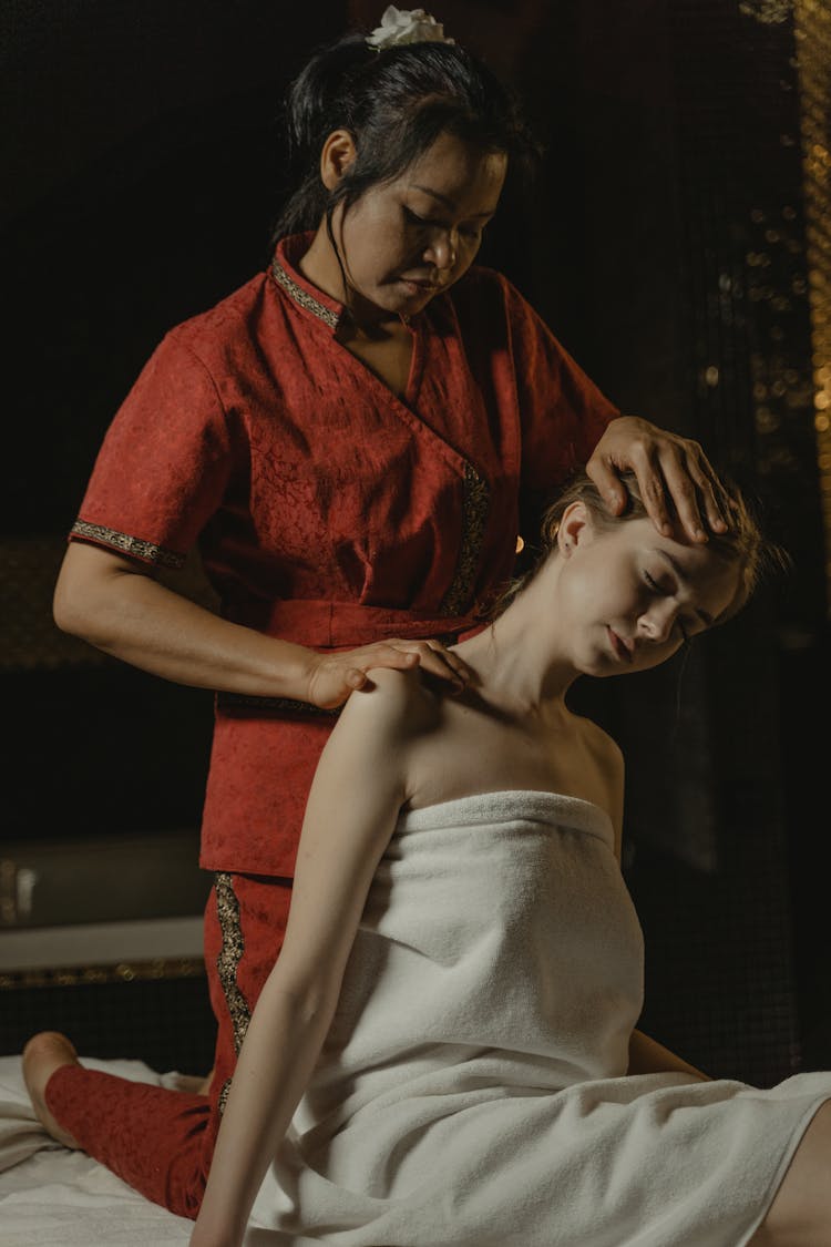 Woman In Red Massaging A Woman's Shoulder And Head