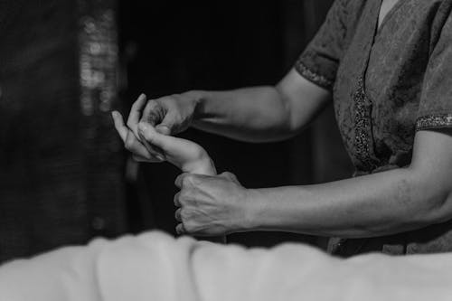Free Grayscale Photo of a Woman Massaging a Person's Hand Stock Photo