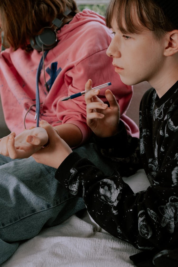 Man Holding A Pen And The Person's Wrist