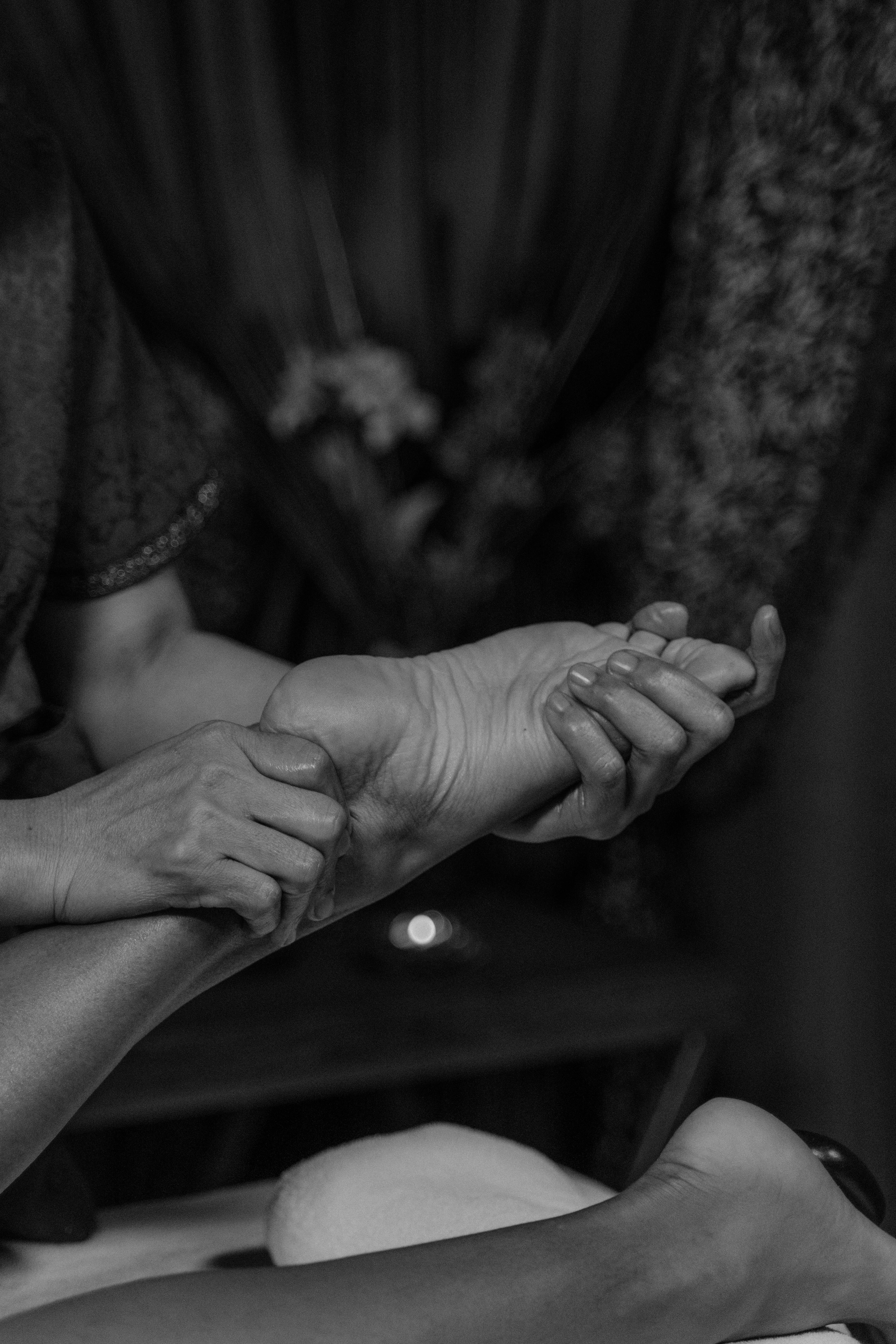 grayscale photo of a person holding a barefoot