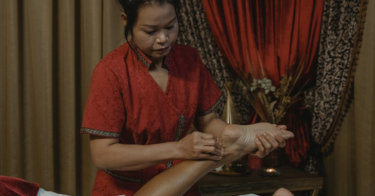 Person receiving a foot reflexology massage with a focus on the soles of the feet.