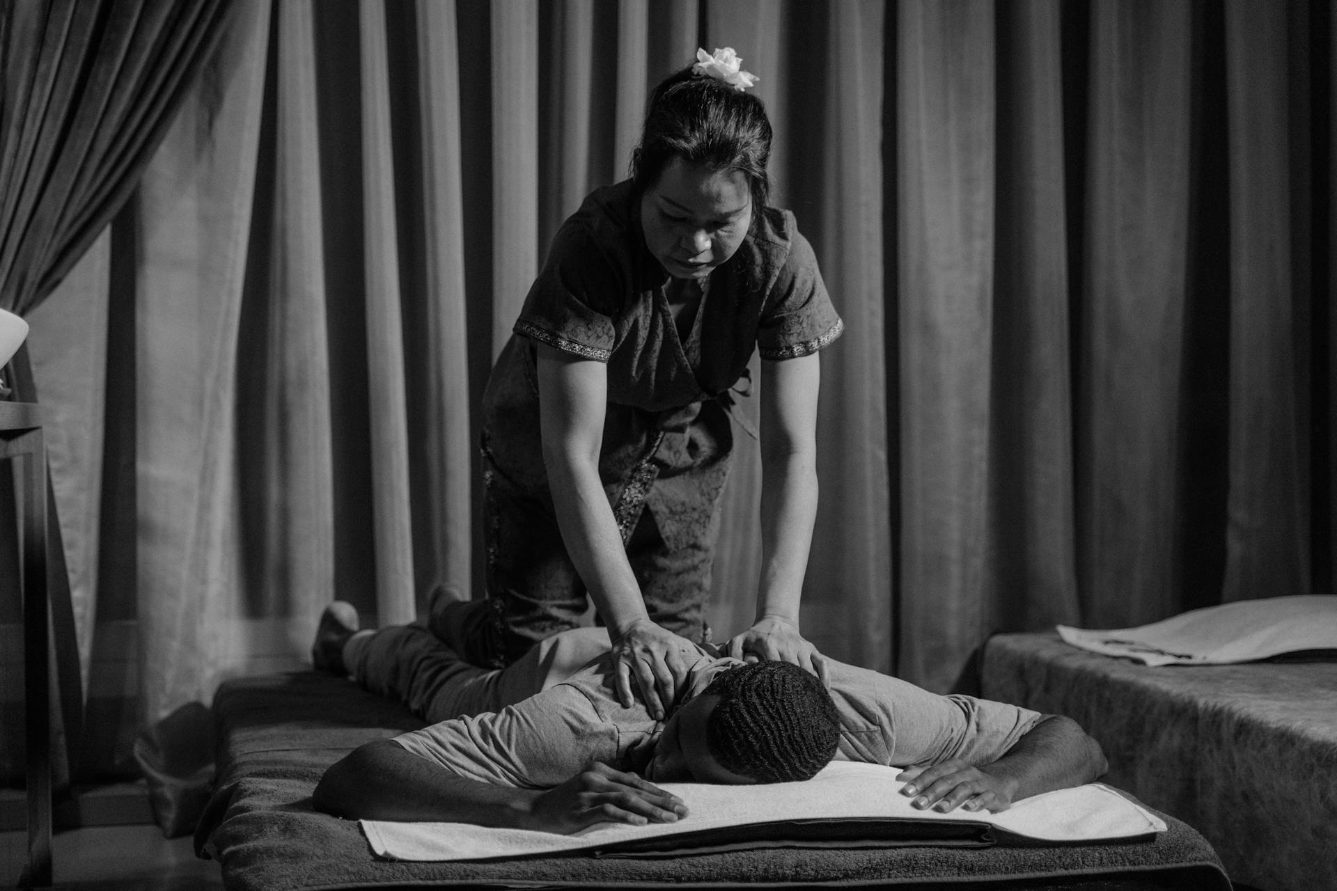 Relaxing black-and-white session depicting massage therapy in a spa setting.