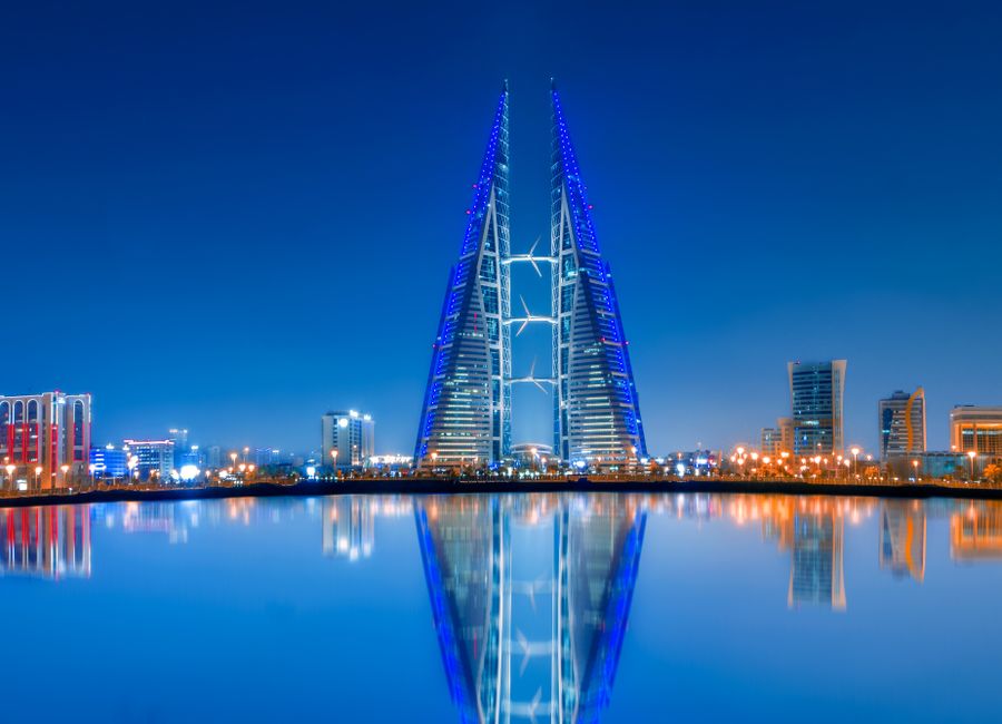 Stunning night view of Bahrain World Trade Center with clear water reflections and modern skyline.