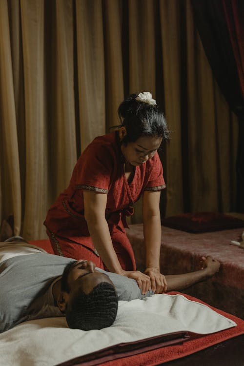 Woman in Red Shirt Massaging Man's Hand