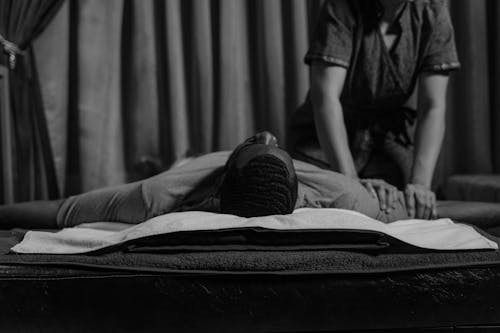 Free Grayscale Photo of a Woman Doing a Massage to a Man's Arm Stock Photo