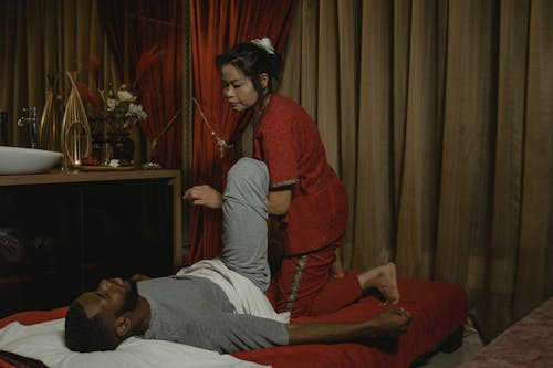 Free A Woman Doing a Body Massage to a Man Stock Photo