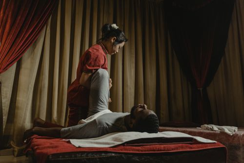 Free Therapist performing a leg stretch on client in a serene spa setting, promoting relaxation and wellness. Stock Photo