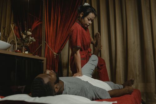 Free Relaxation session with a professional masseur providing therapy for client in a serene salon environment. Stock Photo