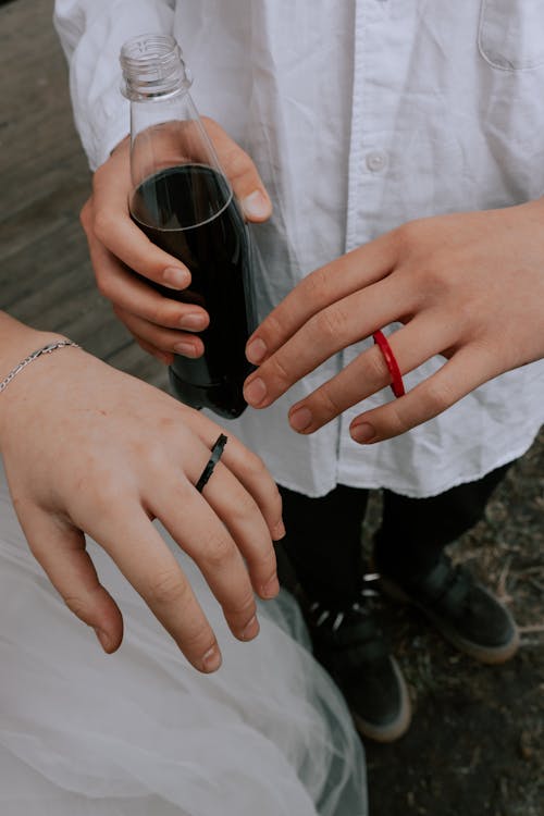 Femme En Bague En Argent Tenant Une Bouteille En Verre Noir