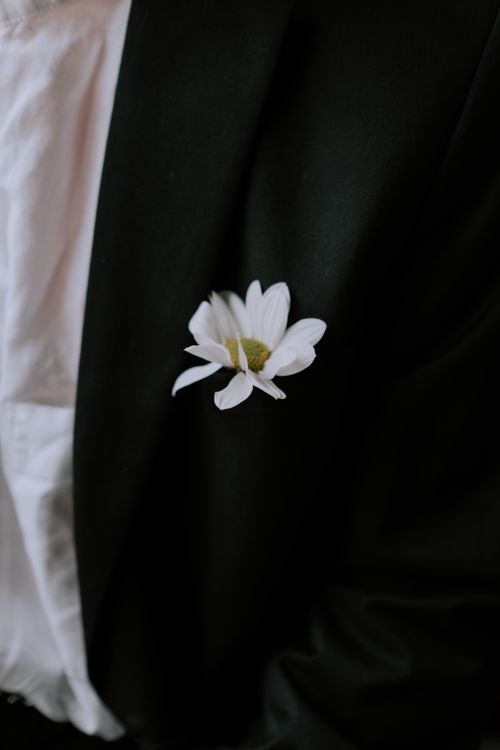 Free A delicate white flower elegantly tucked in a black blazer pocket, symbolizing sophistication. Stock Photo