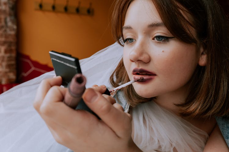 Woman Putting On Lipstick