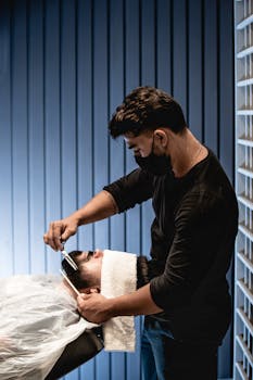 Man getting a beard trim in a stylish barbershop on a relaxed day in João Pessoa, Brazil.
