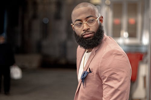 
A Bearded Man Wearing a Pink Blazer and Eyeglasses