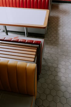 Stylish retro diner seating with colorful booths and hexagonal floor tiles.