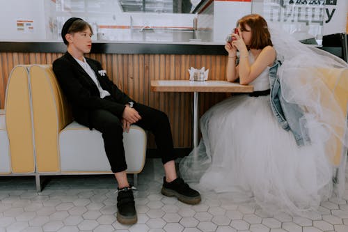 A bride and groom capturing wedding moments in a café setting, with a creative modern twist.