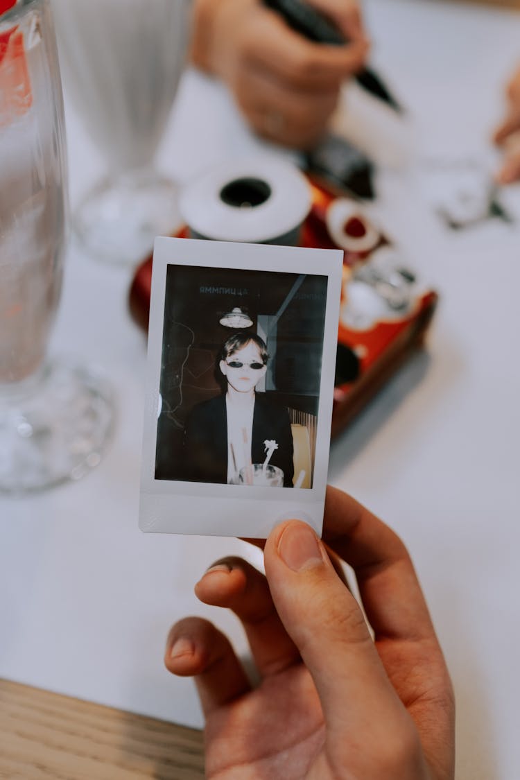 A Person Holding A Photo Of A Man