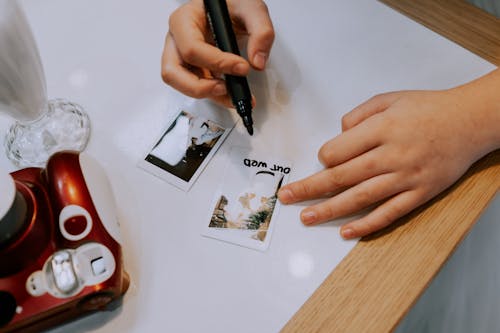Person Writing on Polaroid Picture