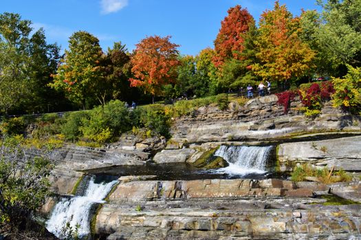 Beautiful fall scenery with waterfall and colorful trees in Ottawa, Canada. Perfect for nature lovers.