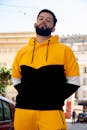 A Bearded Man Wearing a Black and Yellow Hoodie