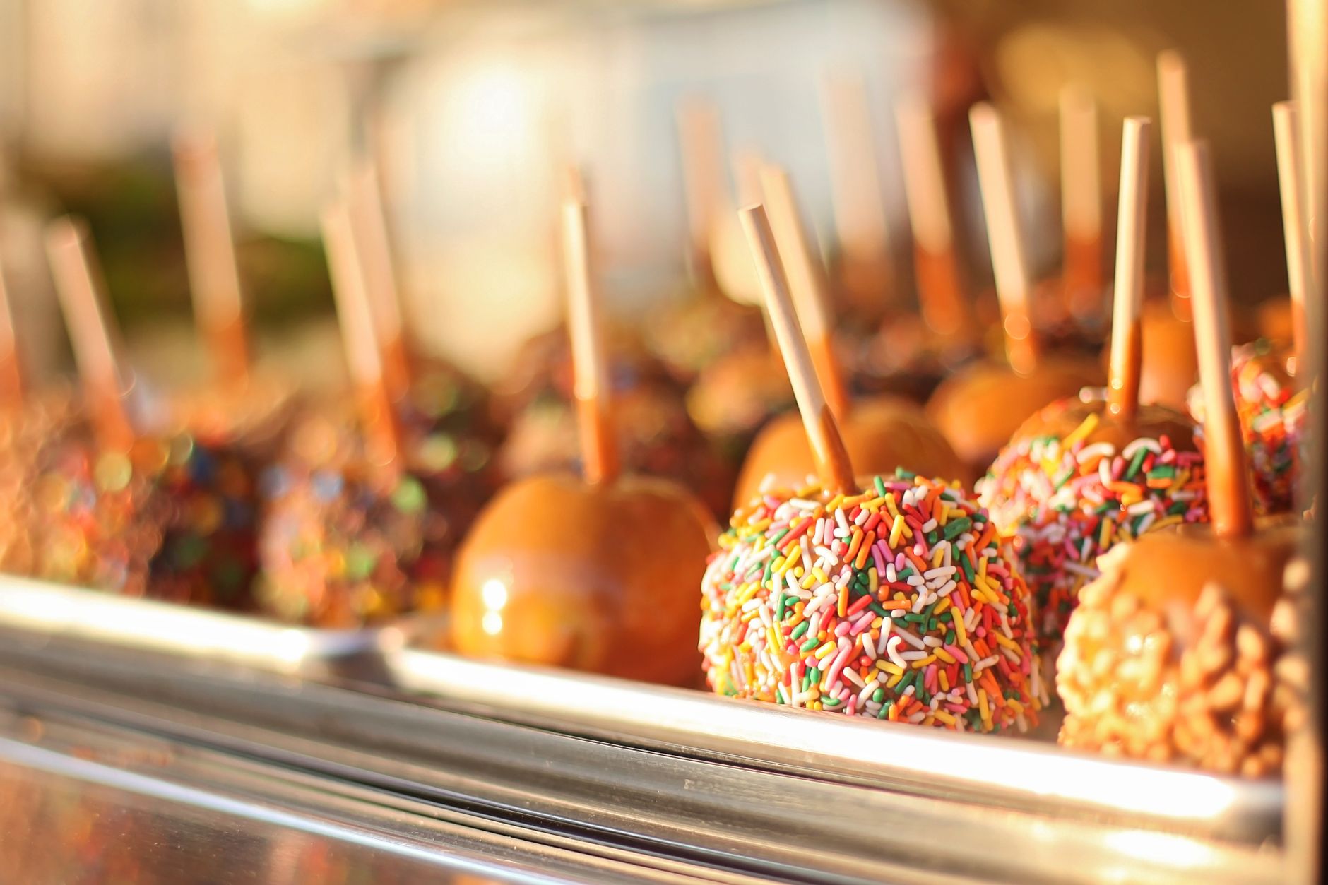 Caramel apple dip with various toppings on a platter