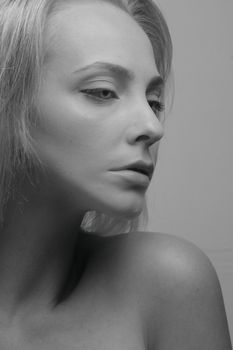 Black and white studio shot of a woman's side profile with bare shoulder.