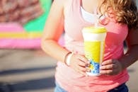 Woman Wearing Pink Tank Top Holding A Tumbler