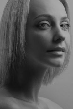 Striking black and white close-up portrait of a woman showcasing elegance and beauty.