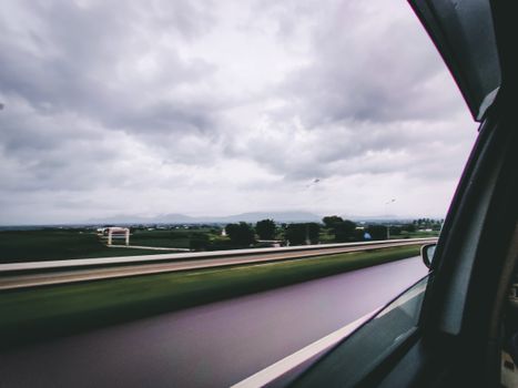 Capture of a drive through scenic landscape in India under a cloudy sky, emphasizing travel and movement.