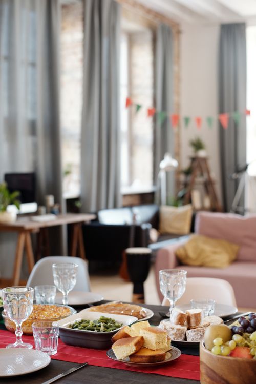 Free Elegant indoor dining setup with various dishes and festive decorations for a holiday celebration. Stock Photo