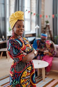 Joyful moment of an African family in vibrant attire celebrating at home with smiles and tradition.