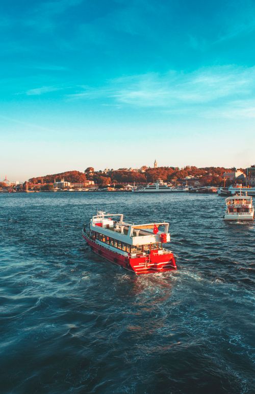 Free Vibrant ferry sails across the scenic Bosphorus in Istanbul, Turkey with a clear blue sky backdrop. Stock Photo