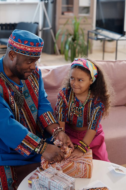 Photo Of Father Helping Daughter To Wrap Gifts