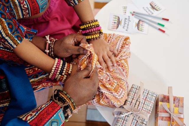 Hands placing a wrapped gift together, representing the act of transferring Family Investment Company growth shares between generations