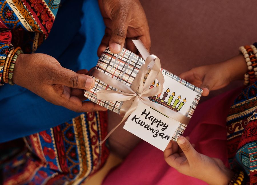 Celebrating Kwanzaa with a gift exchange wrapped in festive patterns, highlighting cultural traditions.