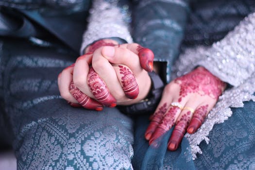 Elegant close-up of a couple's hands adorned with henna, symbolizing love in a traditional ceremony.
