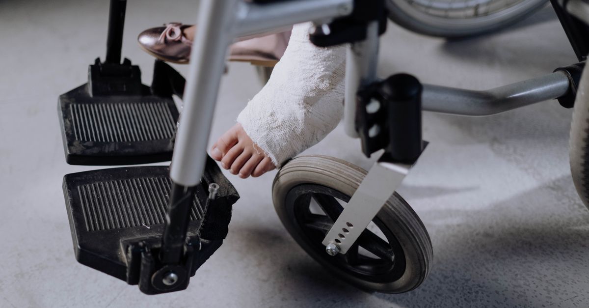 Rüyada Hastalanmak - Rüya Tabiri ve Anlamı - Close-up of an injured foot in a cast resting on a wheelchair, indoors.