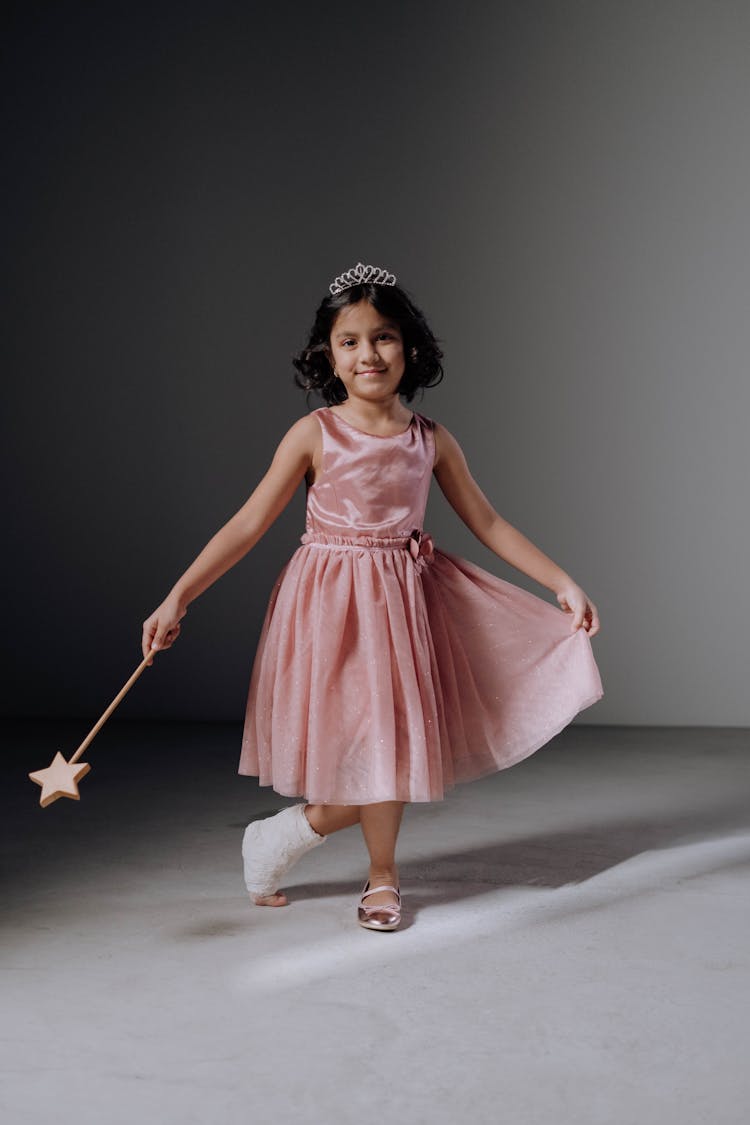 A Girl In Pink Dress Doing A Curtsy