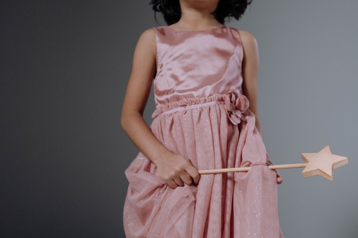 Girl in a pink dress holding a star magic wand