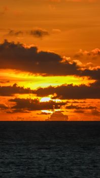 Captivating view of the sunset over Intermares Beach, Brazil, with vibrant orange skies and silhouetted clouds.