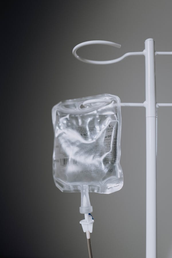 Close-up Photo of an IV Fluid Hanging on Pole