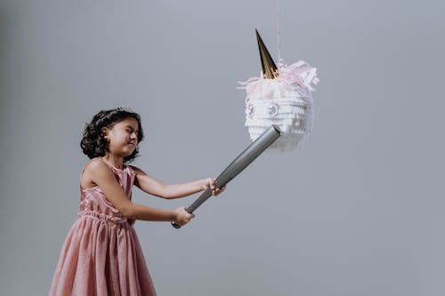 A Girl in Pink Dress Holding a Baseball Bat