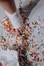 Person in White Long Sleeve Shirt Holding Yellow and White Flower Petals