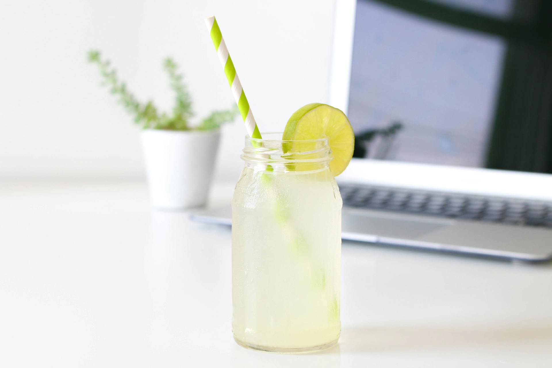 A fresh and delicious lemonade served in a mason jar, complemented by a lime slice, perfect for a refreshing break.