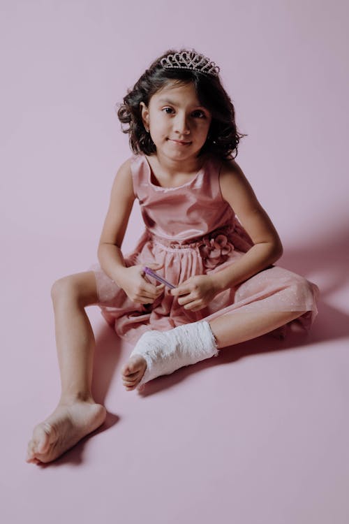 Free A Girl in a Pink Dress Wearing an Orthopedic Cast Stock Photo