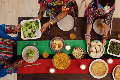 Free Top view of a family enjoying a Kwanzaa feast with traditional foods and vibrant attire. Stock Photo