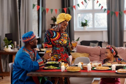 Free A family enjoys a festive meal in colorful traditional clothing, embracing togetherness. Stock Photo